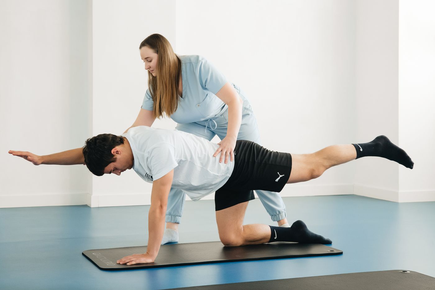 Physiotherapist guiding a patient through an exercise